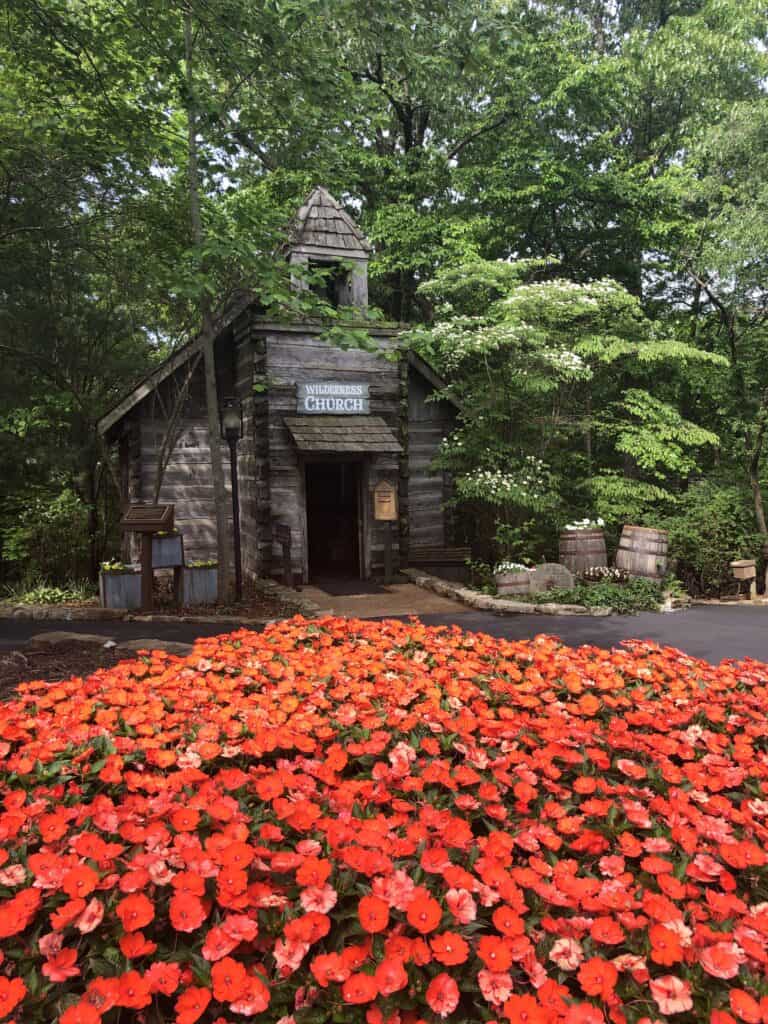 bed of flowers in front of a historic chapel