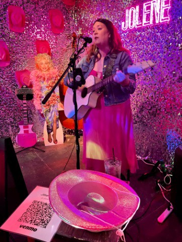 Jillian Riscoe, playing guitar and singing