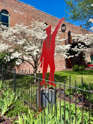 red metal statue in a garden
