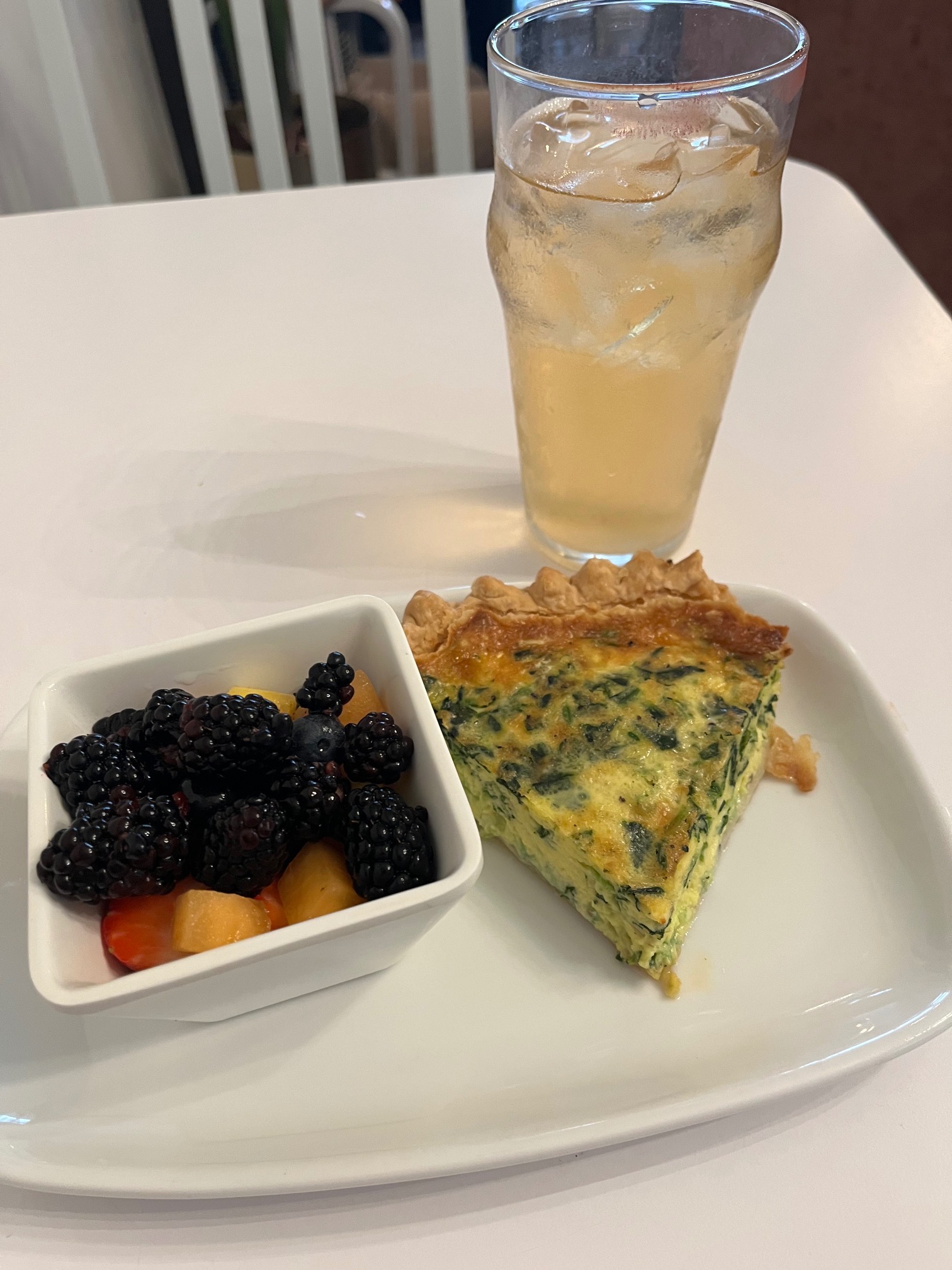 plate of quiche and berries, with an iced tea